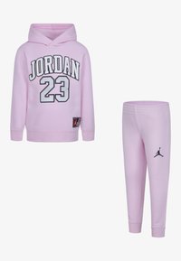 Il hoodie rosa e i pantaloni della tuta coordinati presentano il testo nero "JORDAN 23", polsini a coste e una toppa con logo. Tessuto morbido con una consistenza liscia.