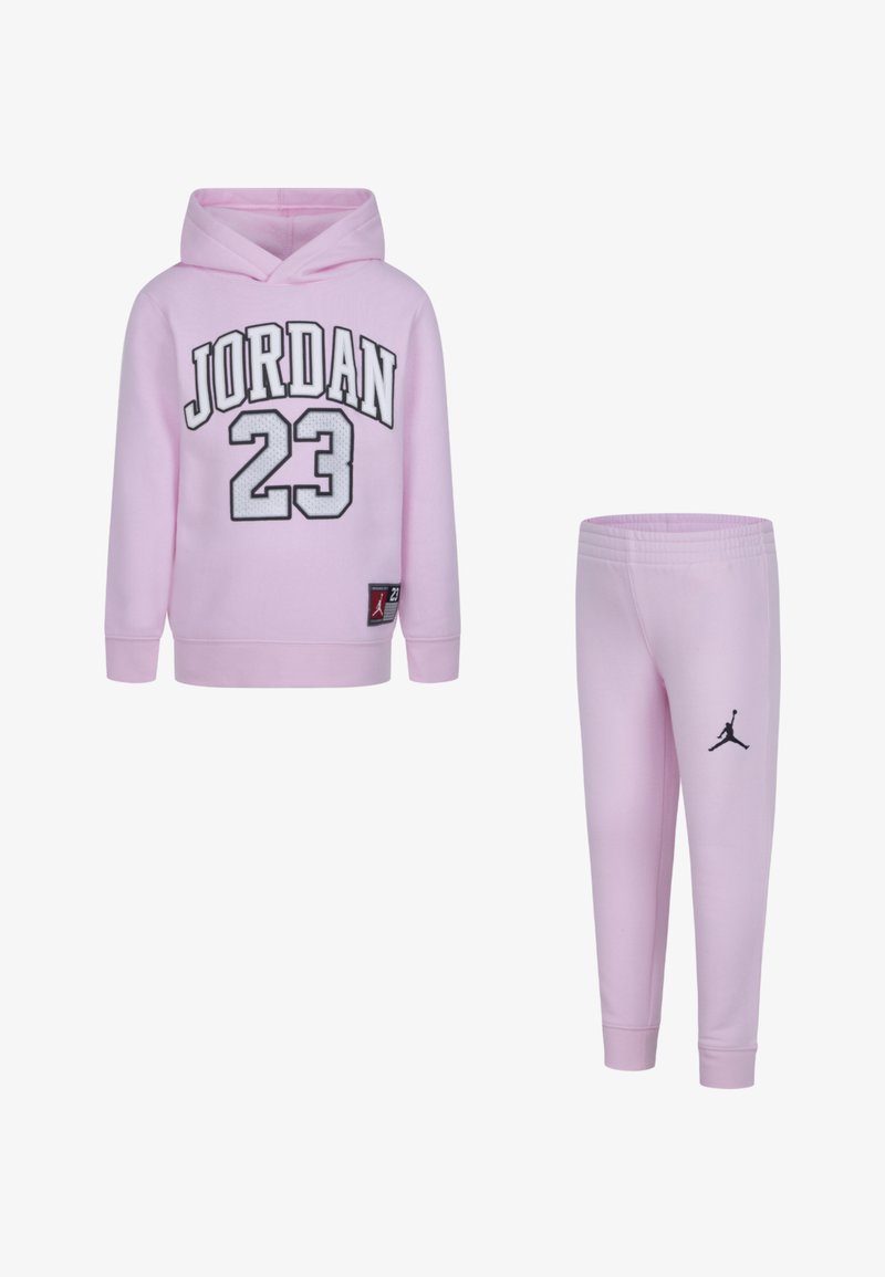 Rozā kapuce un saskaņotas sporta bikses ar melniem "JORDAN 23" uzrakstiem, ribotām aprocēm un logotipa uzšuvi. Mīksta auduma ar gludu tekstūru.