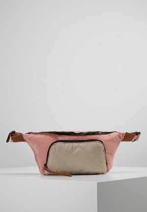 Bolso de cintura de tela acolchada rosa y beige con correa ajustable y bolsillo delantero con cremallera, exhibido sobre una superficie blanca contra un fondo gris.