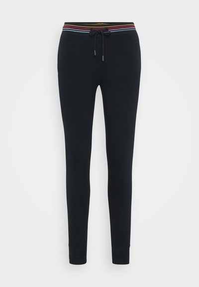 Svarte treningsbukser med stripete elastisk midjebånd, snøring og tettsittende mansjetter ved anklene. Mykt stoff med en glatt tekstur.