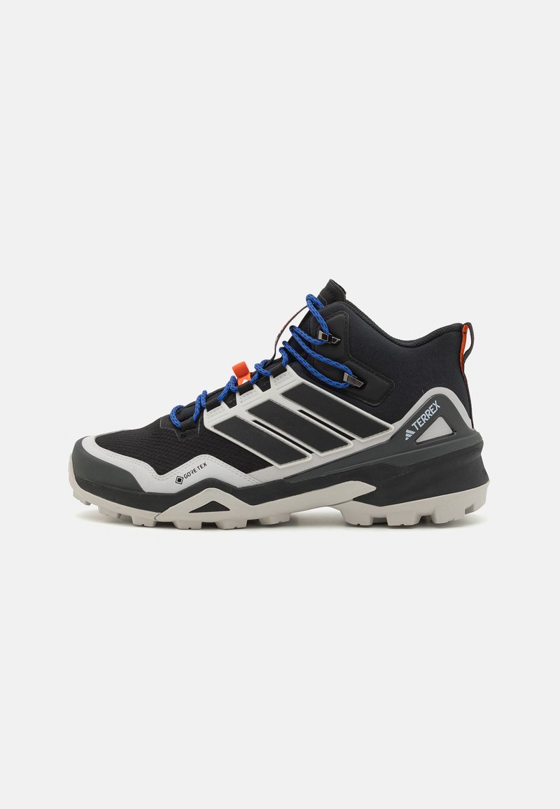 Chaussures de randonnée imperméables noires et grises avec une tige texturée, une semelle moulée et des lacets bleus. Présente des accents orange et un design à trois bandes.
