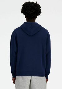Navy blue hoodie with a drawstring hood, long sleeves, ribbed cuffs, and hem, made from soft fabric, featuring a simple design.