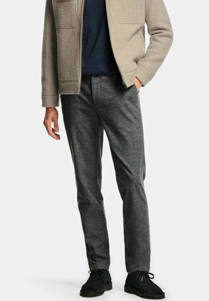 Gray flannel trousers with a slim fit and smooth texture, paired with a beige fleece zip jacket and black suede shoes.