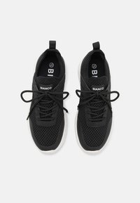 Black mesh sneakers with a textured upper, white rubber soles, flat laces, and branding on the tongue. Designed for comfort and breathability.