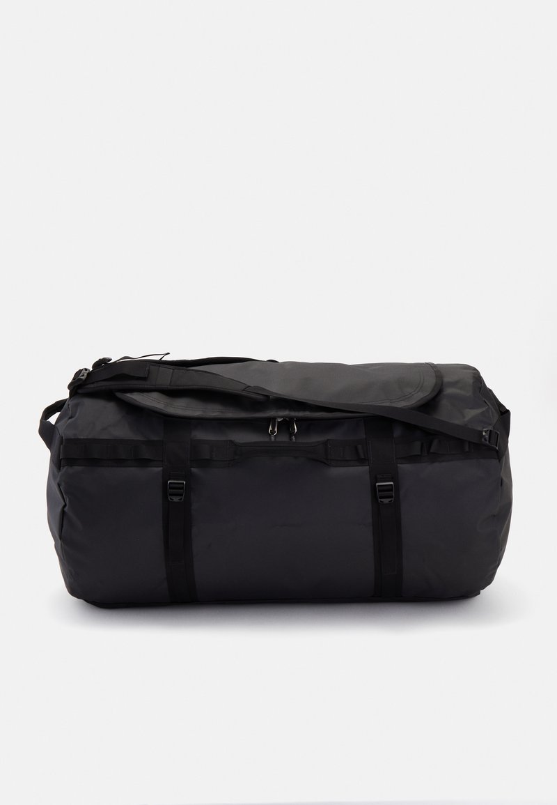 Black duffel bag made of durable material, featuring a rounded shape, a zippered top, and adjustable straps for carrying.