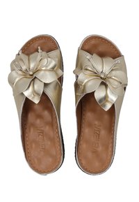 Goldene metallische Riemchensandalen mit großer dekorativer Schleife, offener Zehenpartie und braunem strukturiertem Fußbett. Flache Sohlenkonstruktion.