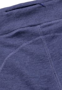 Navyblauwe stof met een gladde textuur, voorzien van contrasterende stiksels en een verborgen rits. Zacht, rekbaar en slim fit ontwerp.