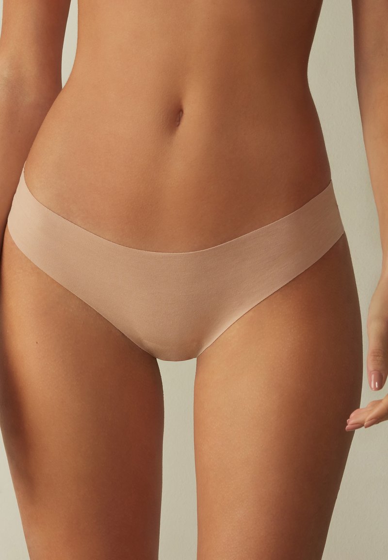 Helle beige Hipster-Unterwäsche aus weichem Stoff, versehen mit einem nahtlosen Design und einem glatten Bund für hohen Tragekomfort.