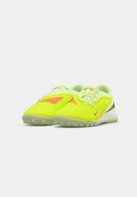 Des chaussures de sport jaune néon éclatantes avec un tissu texturé, des accents roses et une semelle légère présentant différents motifs de traction.