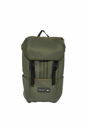Sac à dos rectangulaire vert avec rabat supérieur sécurisé par deux boucles noires, poche zippée à l'avant, poches latérales et un petit écusson avec le logo Adidas.