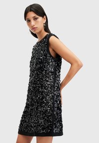 Abito nero senza maniche coperto di paillettes, con scollo rotondo e taglio dritto, dalla texture liscia e con bordi neri solidi.