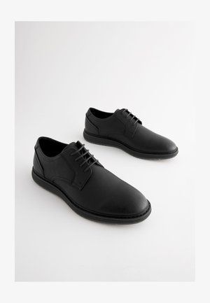 Czarne skórzane buty o gładkiej fakturze, zaokrąglonym nosku i sznurowanym fasonie. Wyposażone w miękką wkładkę i gumową podeszwę zapewniającą przyczepność.