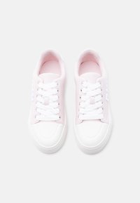 Ζευγάρι ανοιχτό ροζ και λευκά αθλητικά παπούτσια με λευκά κορδόνια, φωτογραφημένα από πάνω σε απλό λευκό φόντο.