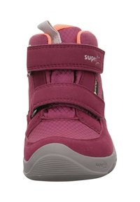 Zapatilla alta vibrante de color rosa, hecha de material textil y sintético, que cuenta con dos correas ajustables de Velcro y una superficie texturizada.