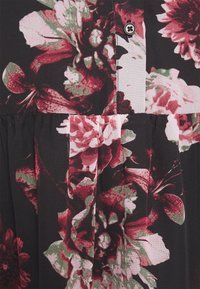 Tissu noir avec des motifs floraux vibrants en rose et rouge. Dispose d'une fermeture à boutons et de détails plissés à la taille.