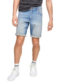 Vaalean siniset farkkushortsit, joissa on kääritty helma, viisi taskua, vetskari ja vaaleanruskea nahkaleima. Yhdistettynä valkoisiin sneakereihin.