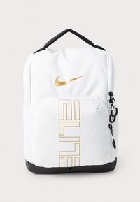 Mochila blanca con el logotipo dorado de Nike y el texto "ELITE". Material texturizado, detalles en negro en la parte inferior y en la cremallera, y un asa en la parte superior.
