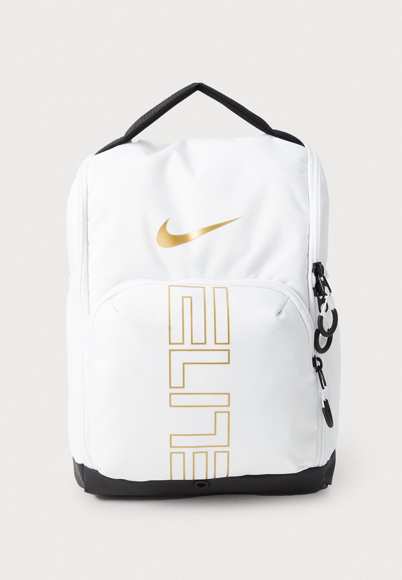 Mochila blanca con el logotipo dorado de Nike y el texto "ELITE". Material texturizado, detalles en negro en la parte inferior y en la cremallera, y un asa en la parte superior.