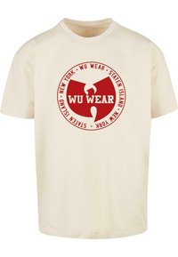 Cremefarvet bomulds t-shirt med et rundt rødt logo, der har teksten "WU WEAR," "NEW YORK," og "STATEN ISLAND" i hvidt. Kortærmet, klassisk pasform.