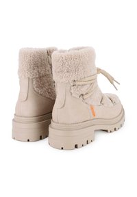 Botas de tobillo beige con un borde de pelusa, ante texturizado y diseño de cordones. Suela gruesa y resistente para tracción y estabilidad.