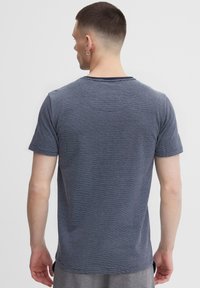 Navy and white striped short-sleeve T-shirt in a soft fabric, crew neck, with a slightly loose fit and side slits at the hem.
