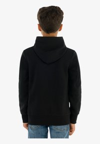 Czarna bluza z kapturem wykonana z miękkiego materiału, z kapturem i ściągaczami na rękawach. Widok z tyłu pokazuje prosty design bez widocznych logo ani wzorów.