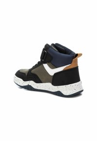 Zapatilla de media caña en negro, oliva y azul marino. Presenta una parte superior de cuero texturizado, acentos blancos y una suela de goma moteada. Incluye una correa ajustable.