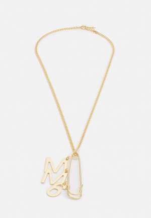 Collar de cadena en tono dorado con un gran imperdible y letras colgantes "M", "M" y "O" como dijes sobre un fondo blanco.