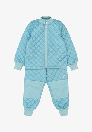 Dvojdielny prešívaný set svetlomodrej farby, ktorý obsahuje bundu na zips a nohavice. Dopĺňajú ho rebrované manžety a logo na nášivke na nohaviciach.