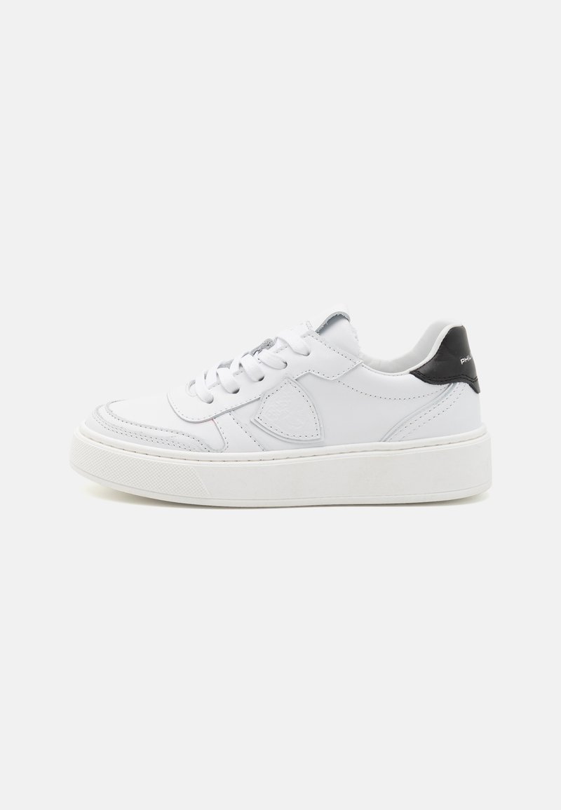 Baskets en cuir blanc avec un col rembourré et un accent noir au talon, dotées d'un laçage et d'une semelle plateforme texturée.
