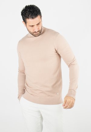 Pull en maille beige clair à manches longues et col rond. Doté de poignets et d'un ourlet côtelés, avec une petite étiquette logo près de l'ourlet.