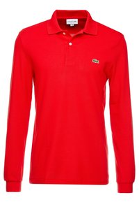 Polo shirt rosso a maniche lunghe realizzato in tessuto liscio, con una chiusura a due bottoni e un piccolo logo verde di Lacoste sul lato sinistro del petto.