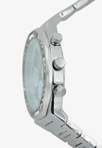 Reloj de metal plateado con esfera redonda, dos botones laterales, bisel texturizado y una correa de eslabones, con una esfera de color azul claro.