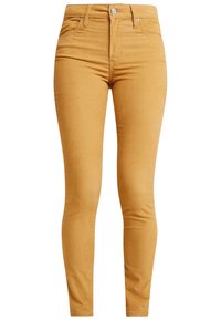 Pantalones ajustados en amarillo, confeccionados en tela de algodón. Cuentan con una cintura alta, bolsillos frontales y una textura lisa sin patrones.
