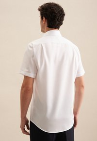 Korte mouwen witte shirt van gladde stof, met een klassieke kraag en een afgeronde zoom, die een eenvoudig ontwerp laat zien zonder zichtbare patronen of accenten.