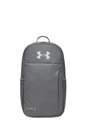 Grijze Under Armour rugzak met voorvak met rits, bovenste draaggreep, zijdelingse mesh vakken en zichtbare logo’s op het voorpaneel.