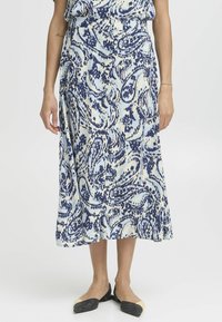 Jupe mi-longue en tissu léger, arborant un motif paisley bleu et blanc, avec un devant à boutons et un bas évasé.