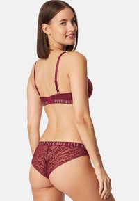 Burgunderlingerie-Set bestehend aus einem Spitzen-BH mit verstellbaren Trägern und passenden Spitzen-Shorts mit einem Branding-Bund.