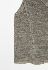 Grauer ärmelloser Oberteil mit strukturiertem Strickdesign, leicht abgerundetem Saum und schrägen Schulternähten. Weiches Material mit subtiler Melierung.