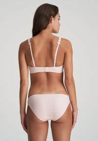 Light pink lingerie set featuring a checkered pattern, lace-trimmed straps, and a hook-and-eye closure at the back. Soft and smooth texture.