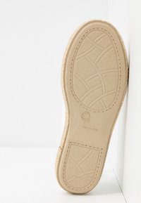 Semelle d'une chaussure beige avec motifs de adhérence texturés, taille 7, marquée "Made in Spain", photographiée sur fond blanc.