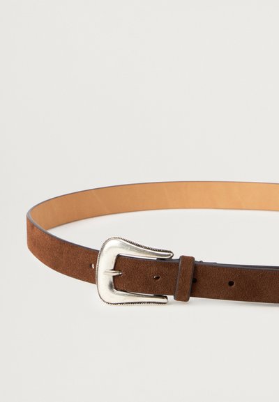 Καφέ σουέτ ζώνη με μεταλλική αγκράφα σε ασημί απόχρωση. Διαθέτει λείο εσωτερικό επένδυση και πολλές τρύπες για ρυθμιζόμενη εφαρμογή. Λεπτός σχεδιασμός.