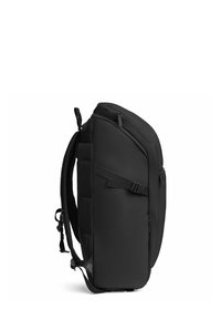 Sac à dos noir et élégant avec une forme profilée, fabriqué à partir de matériel durable. Il dispose de bretelles rembourrées et de plusieurs compartiments zippés.