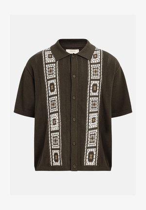 Dark olive short-sleeve knit shirt with button front, collar, and white geometric square patterns running vertically on both sides.
