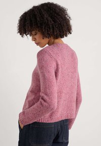 Różowy, dziany sweter z długimi rękawami i okrągłym dekoltem. Posiada teksturowane wykończenie z drobnymi plamkami czerwieni i niebieskiego, ściągaczowy dół.