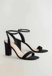 Sandales à talons hauts en suède noir avec un bout carré, deux brides à l'avant et des brides de cheville, dotées d'un talon bloc épais.