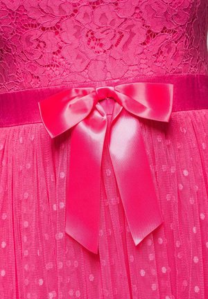 Robe en dentelle rose vif avec jupe en tulle à pois et large ruban en satin noué en nœud à la taille.