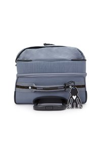 Gray wheeled bag with a textured surface, zippered compartments, black accents, a handle, and a playful character tag attached.
