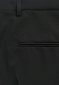 Schwarze Herrenhose aus strukturiertem Stoff. Verfügt über eine Gesäßtasche mit schmalem Öffnung und glatten Nähten entlang der Nähte.