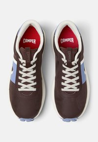 Brown sneakers with blue accents and white laces, featuring a red interior and the brand name "Camper" prominently displayed.